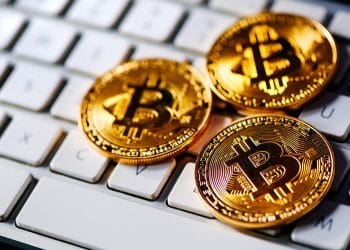 Representación de monedas de bitcoin sobre teclado de computador personal. Fuente: stevanovicigor/elements.envato.com