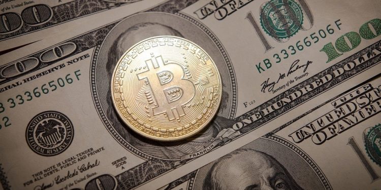 Moneda de bitcoin sobre billete de 100 dólares. Fuente: Petre Barlea/pixabay.com