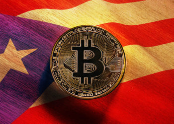 Moneda de Bitcoin sobre mesa con bandera de Puerto Rico superpuesta. Composición por CriptoNoticias. stevanovicigor / elements.envato.com; wirestock / freepik.com